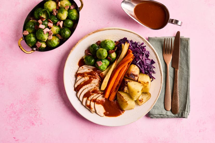 Take your places for our flavoursome feast of garlic and herb-rubbed turkey breasts, thyme-roasted parsnips, carrots and potatoes, Brussels (with smoky bacon, to win over those sprout sceptics!), braised red cabbage and a rich garlic and herb gravy. It’s a cracker!